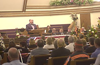Walser's friend Ed Miller speaks at his funeral Monday.