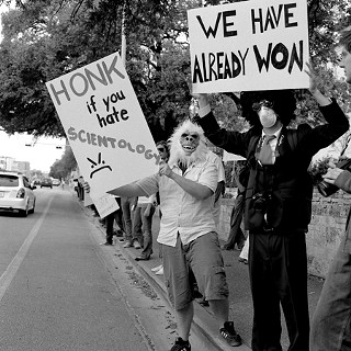 Anonymous protesters picketed the Church of Scientology of Texas Sunday,
as part of an Internet-inspired day of protest against the L. Ron
Hubbard-founded church. The ultraloosely confederated group of Internet
trolls, amateur killjoys, and hackers known only as “Anonymous” normally
confine their actions to the Web: posting offensive, spoiler-filled
(and often hilarious) info and images online, like a recent campaign
ruining the ending of the final <i>Harry Potter</i> novel. More recently,
Anonymous has targeted the Church of Scientology for its legal
overzealousness in going after leaks of secretive info to the Web (like
the infamous Tom Cruise video and purported upper-level teachings
costing thousands of dollars to learn). Organ-izing online, Sunday, Feb.
10, Anonymous protesters across the county targeted Scientology
establishments – this time, for more than the all-important <i>lulz</i> (Latin
for “laugh out loud.”) Wells Dunbar