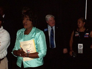 Roy LaVerne Brooks (foreground, in light blue jacket) is challenging incumbent party chairman Boyd Richie (standing behind her).