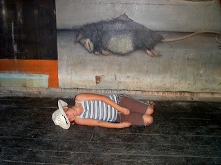 Overcome by nostalgia only her parents experienced, Kearie Lee Berry IV lays down in front of her favorite rat in the Raul’s mural.