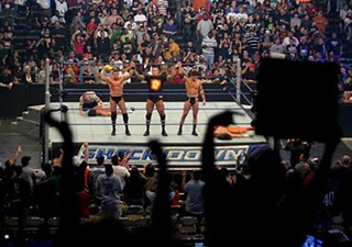 WWE Heavyweight Champion John Cena lifts challenger Edge above his head