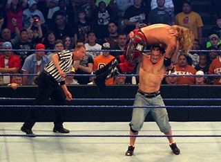 WWE Heavyweight Champion John Cena lifts challenger Edge above his head