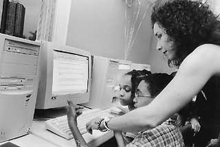 A volunteer assists participants in Girlstart's Web scavenger hunt.