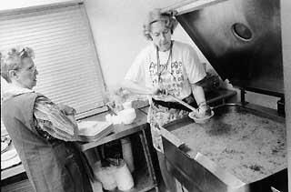 Ruth Meaney, a volunteer at Caritas, pours soup for clients.