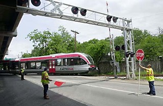 Workers gave the MetroRail train a series of test runs at railroad crossings Tuesday, including this one along the northbound frontage road of I-35 across from the Hancock Center. The crossing gates were not working at the time of the test. Capital Metro's rail system is on indefinite hold while transit authorities work out some safety kinks.