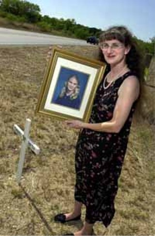 Martha Early holds a portrait of her daughter at the site of the accident.