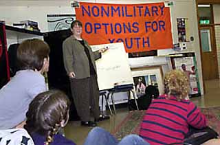 Teresa Penepinto of the Central Committee for Conscientious Objectors explains military life from a pacifist perspective to Johnston High School students.