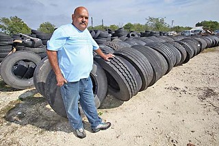 Victor Almaguer stands among the tons of scrapped city tires he's been accumulating since 2003.
