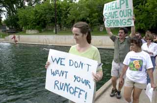 Protesters from the SOS Alliance and Sierra Club try to round up supporters at Barton Springs before heading to Tuesday night's Zoning and Platting Commission meeting.