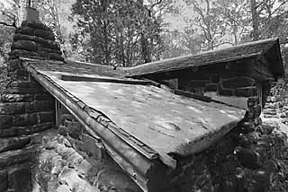 A tarp covers the roof of this Bastrop State Park cabin in need of repair.