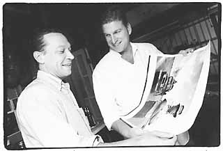 Scott Andersen(l) and Craig Cuny look at a photo of Craig's father Fred